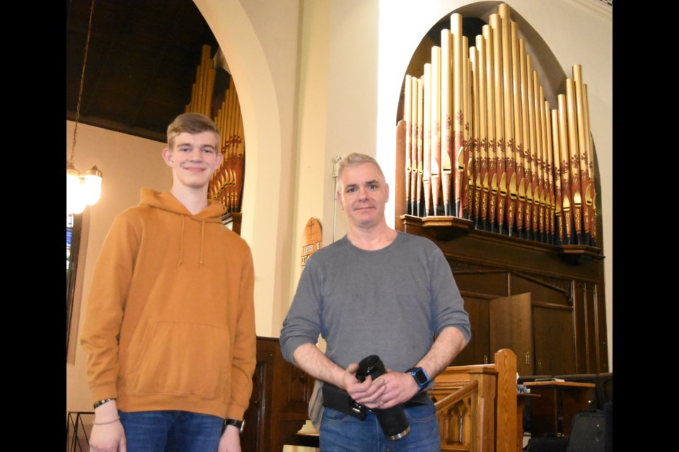 Camron Deans, a parishioner of St. Aidan Anglican Church, and Jason Barnsley, a pipe organ repairman, take a break from cleaning the church's system. Photo by Jason G. Antonio