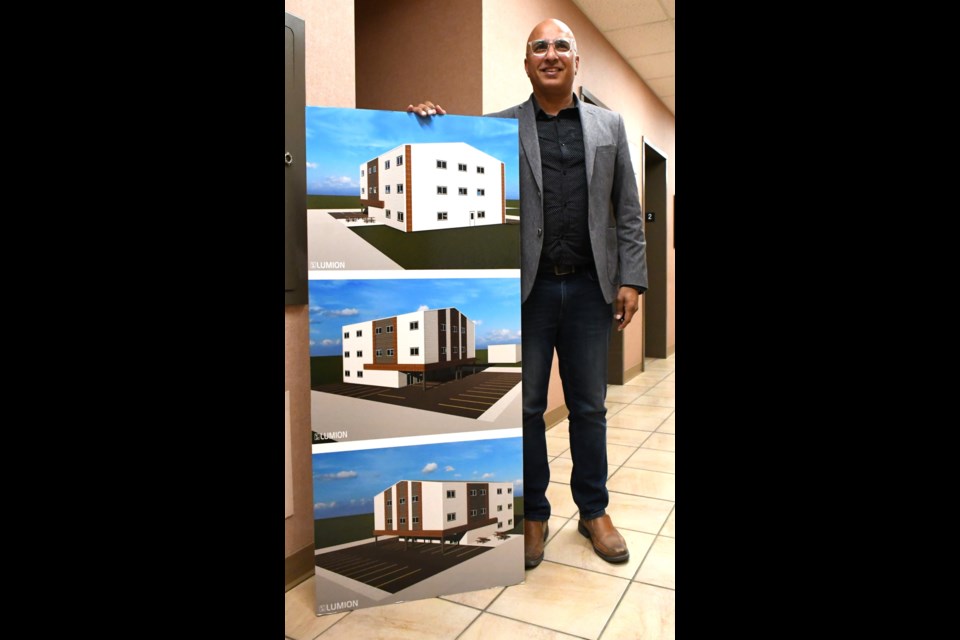 Businessman JC Chhokar holds a poster with an artist's draft of what the apartment complex will look like. Photo by Jason G. Antonio