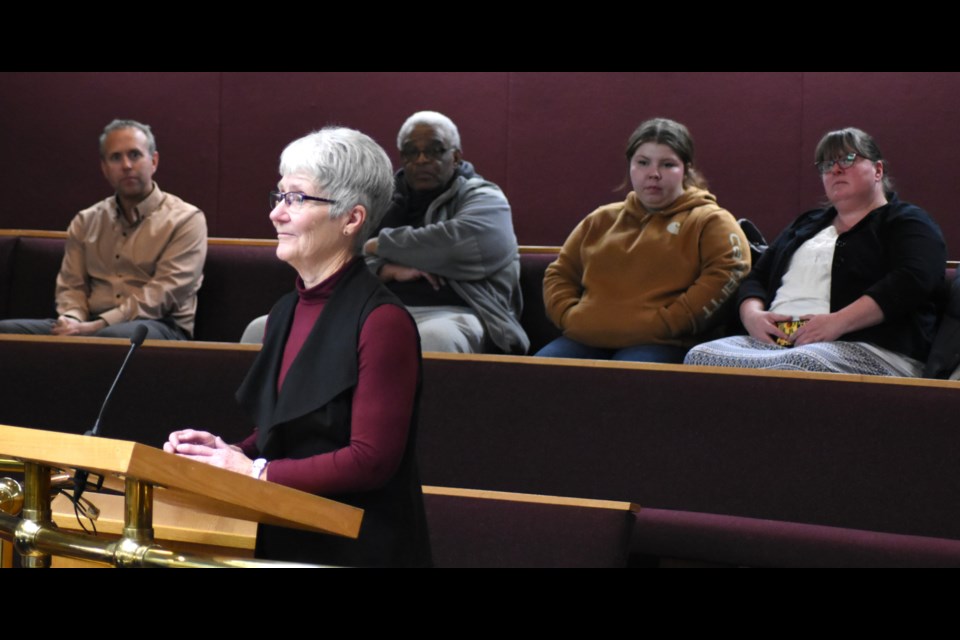 Sharon Oberding, board chairwoman of Hope Ministries (at podium), speaks to council about the group's food security initiatives. In the background are board members, volunteers and staff with the charity. Photo by Jason G. Antonio