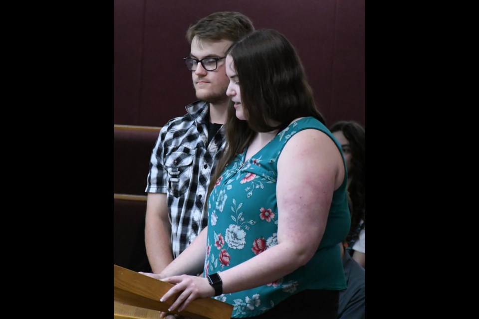 Avery Surtees, chairwoman of the youth advisory committee, speaks to city council, while fellow member Austin Kretsch looks on. Photo by Jason G. Antonio