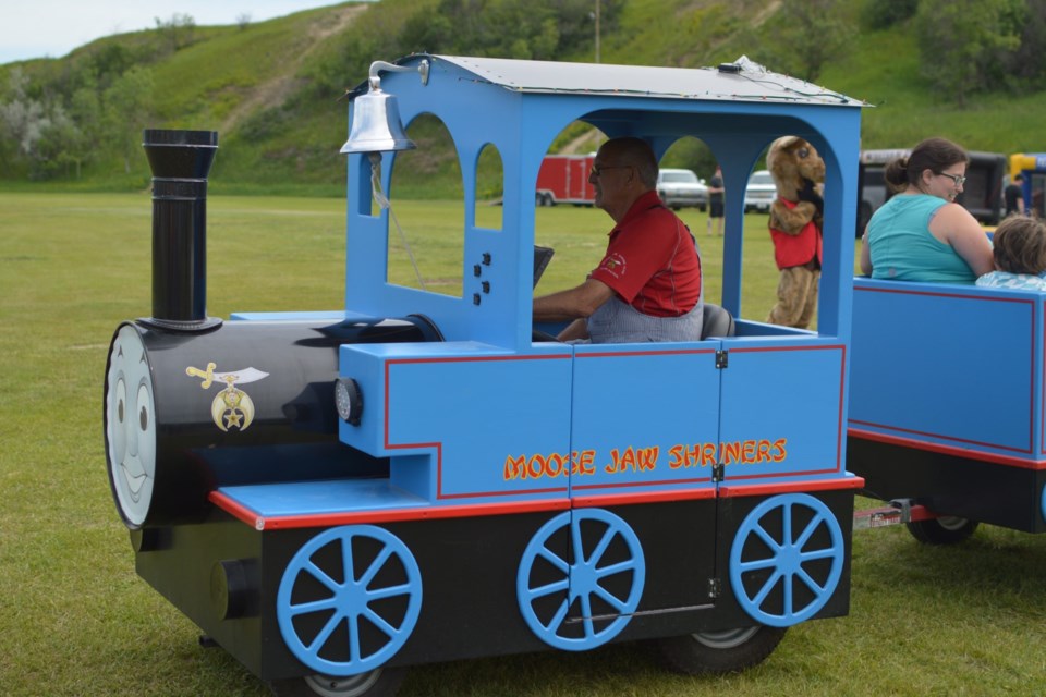 A Shriner taking kids on a tour in the “Thomas the Train” car. 