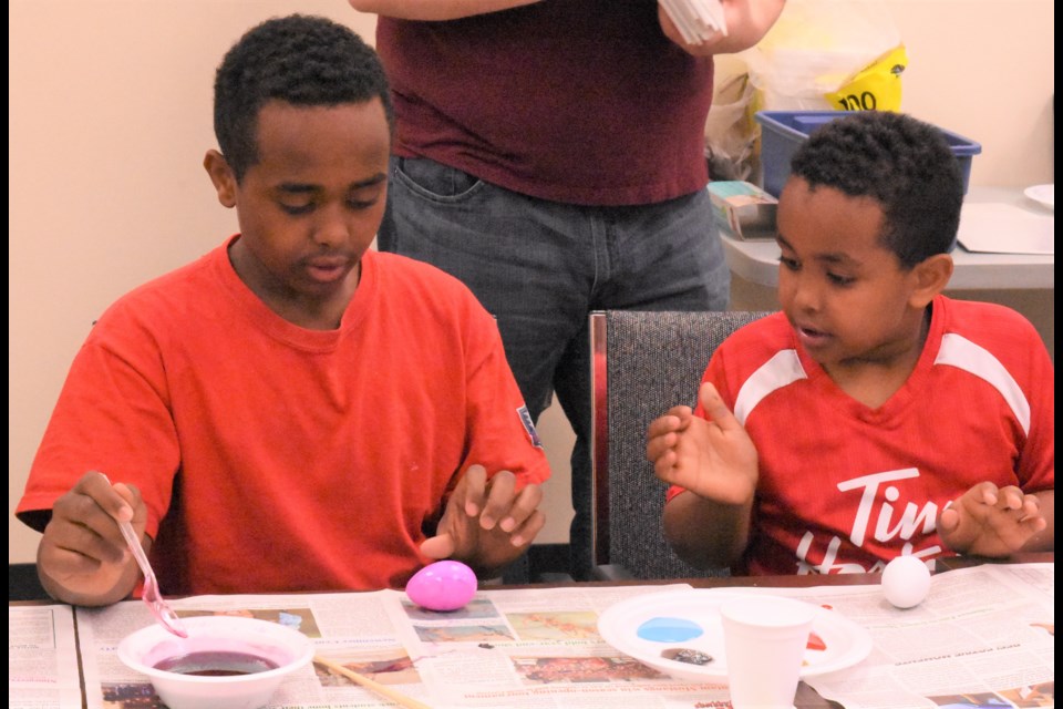 Sudanese brothers Goitom and Mussie Goitom attend their first activity at the Newcomer Welcome Centre and learn how to colour Easter eggs, on April 25. Photo by Jason G. Antonio