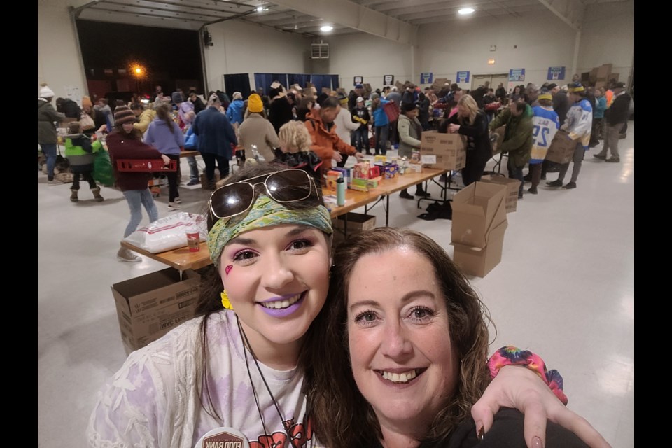 The food bank's Deann Little (right) and her daughter Chelsea pose for a picture during the sorting and packing phase of the food drive at the exhibition grounds. Photo courtesy Deann Little