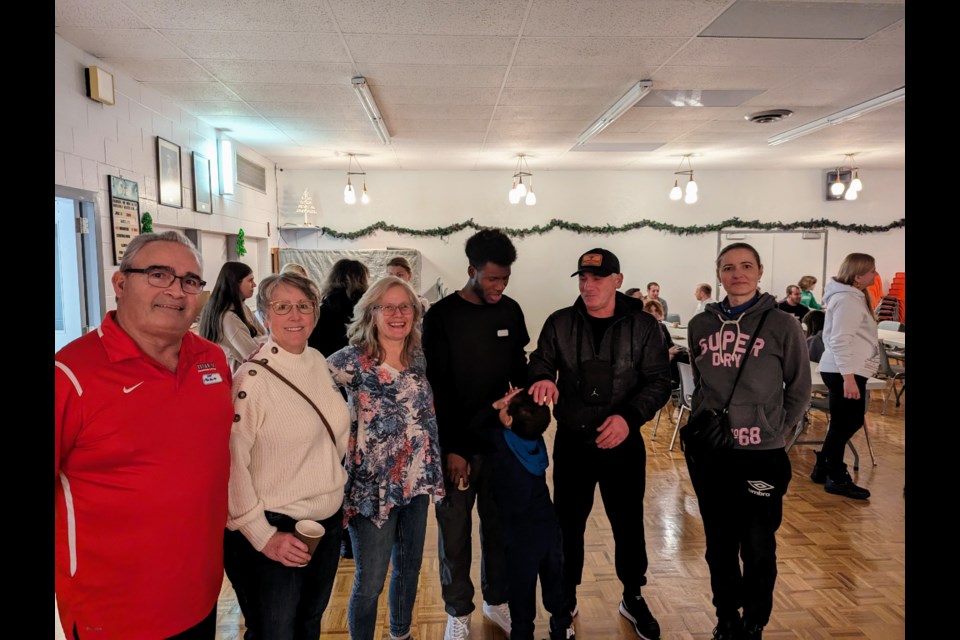 Sponsors Len and Bernie Mintenko (leftmost) and Christy Schweiger (third from left) visiting with Ukrainian newcomers during Sunday's gathering