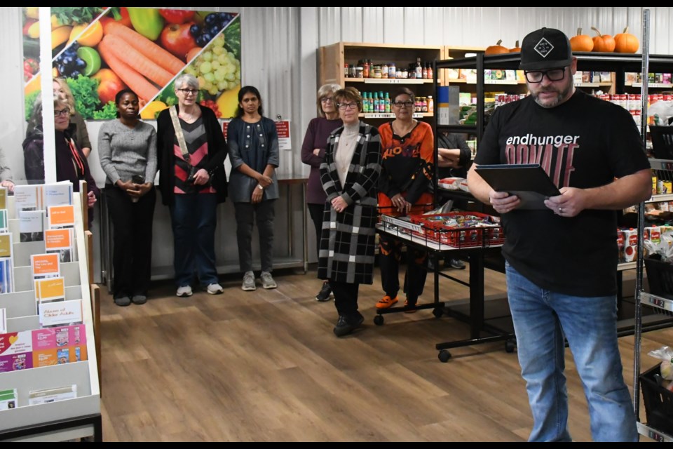 Jason Moore, executive director of the food bank (right), speaks during a grand opening ceremony to celebrate the new food distribution program. Photo by Jason G. Antonio