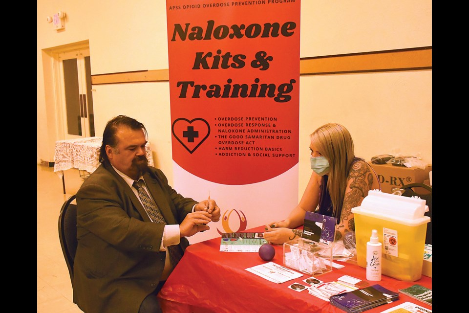 Moose Jaw Wakamow MLA Greg Lawrence learns how to administer a naloxone injection during the community event for International Overdose Awareness Day.