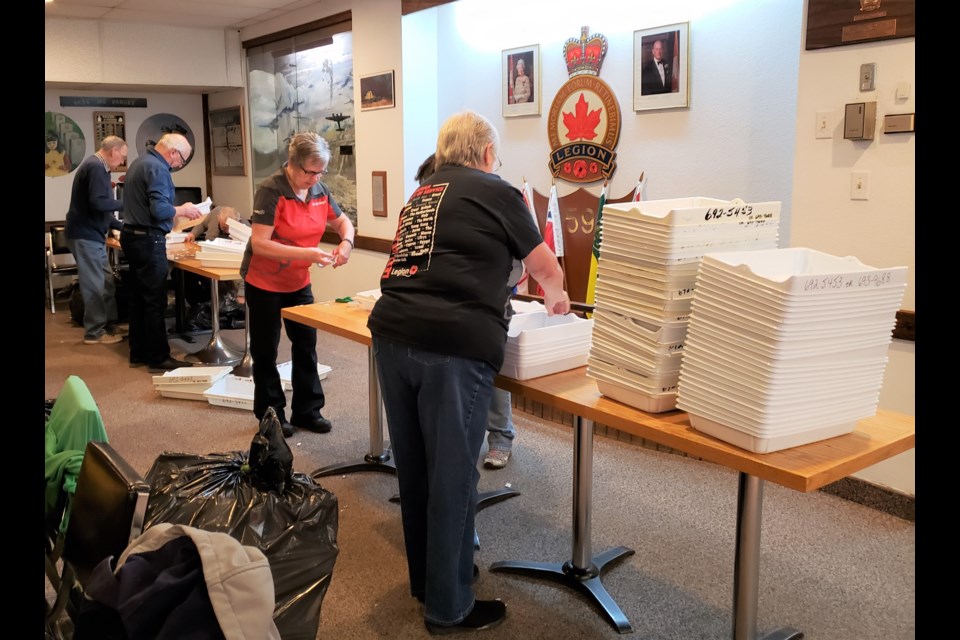 Legion members help organize plastic trays that will soon be filled with poppies, as part of the 2019 poppy campaign. Photo courtesy Bob Travale