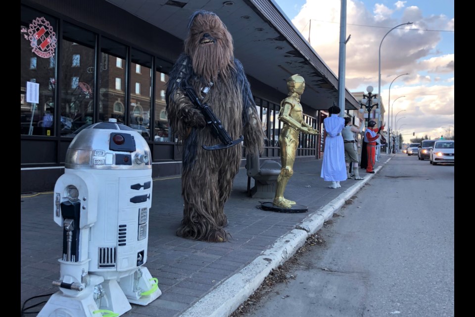 Characters lined up along the sidewalk outside Joe’s Place Youth Centre, to celebrate Star Wars Day in the current style — socially distanced.