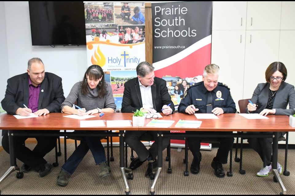 Partners who support the Community Threat Assessment and Support Protocol sign the updated document. Photo by Jason G. Antonio