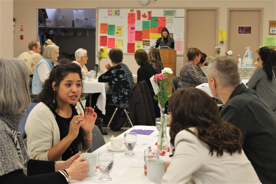 Patrons of the early brunch to celebrate International Women’s Day chat while organizer Isabella Grajczyk welcomes them to the event. 