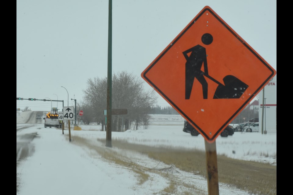 Ministry of Highways employees begin erecting construction signs on Main Street North to warn motorists about upcoming work on the overpass bridge. Photo by Jason G. Antonio