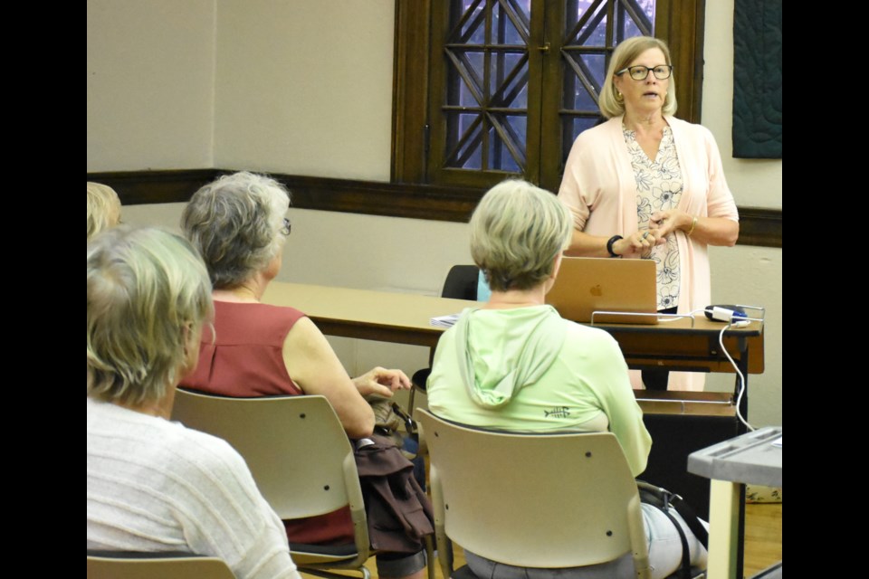 Janie Fries, vice-chair of the heritage advisory committee (standing), speaks to residents about wartime homes at the library. Photo by Jason G. Antonio