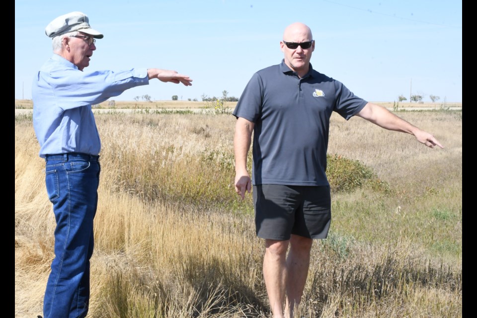 Baildon resident Jerry Kaiser and Darren Newberry with the Saskatchewan Wildlife Federation discuss where to install signs on the property that Kaiser donated. Photo by Jason G. Antonio