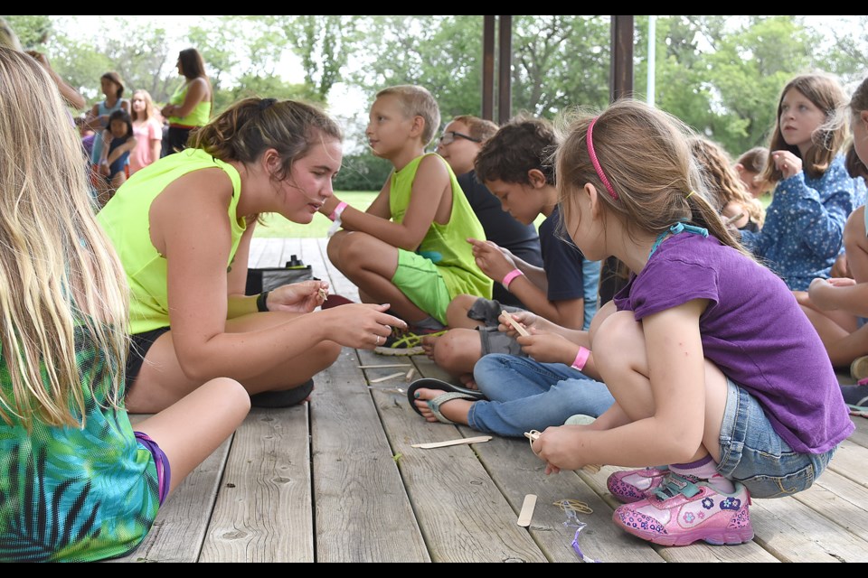 Youngsters work on a popsicle stick project under the watchful eye of a camp counsellor, during the 2019 Summer Play Program. Photos by Larissa Kurz