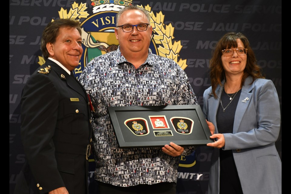 Past board member Darrell Markin (centre) was recognized for five years of service on the board of police commissioners.