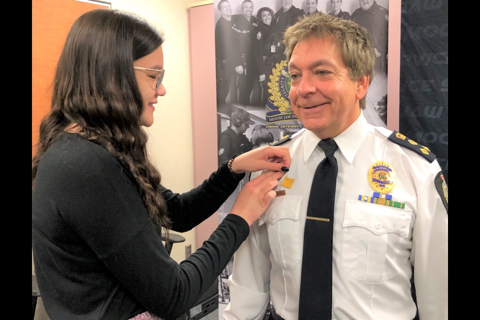 Kayleigh Olson pins a piece of moose hide — actually a small piece of felt — onto Police Chief Rick Bourassa as part of the Moose Hide Campaign kick off on Feb. 19 at the police station. The campaign takes a stand against violence against women and kids. Photo by Jason G. Antonio 