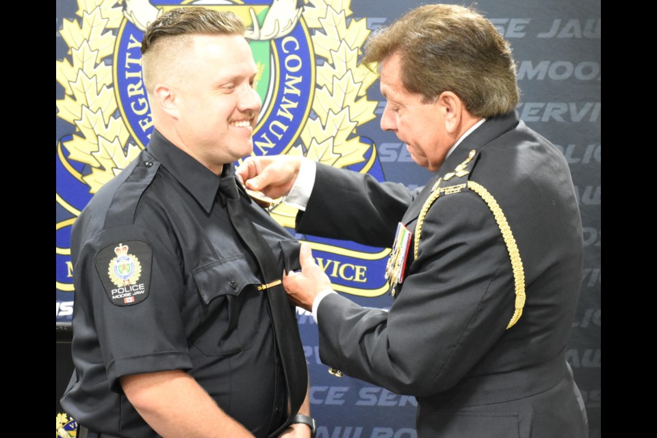 Daniel Heimbecker (left) is presented with the badge of the MJPS by Police Chief Rick Bourassa (right) on July 19.