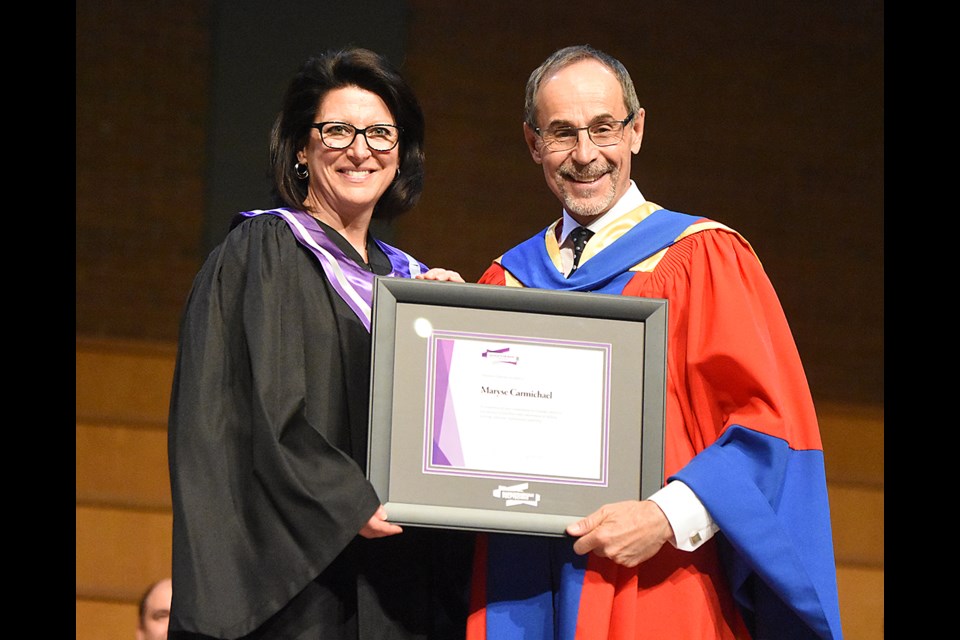 Former Snowbirds commanding officer Lt. Col. Maryse Carmichael receives her Honorary Diploma from Sask Polytech president Dr. Larry Rosia.