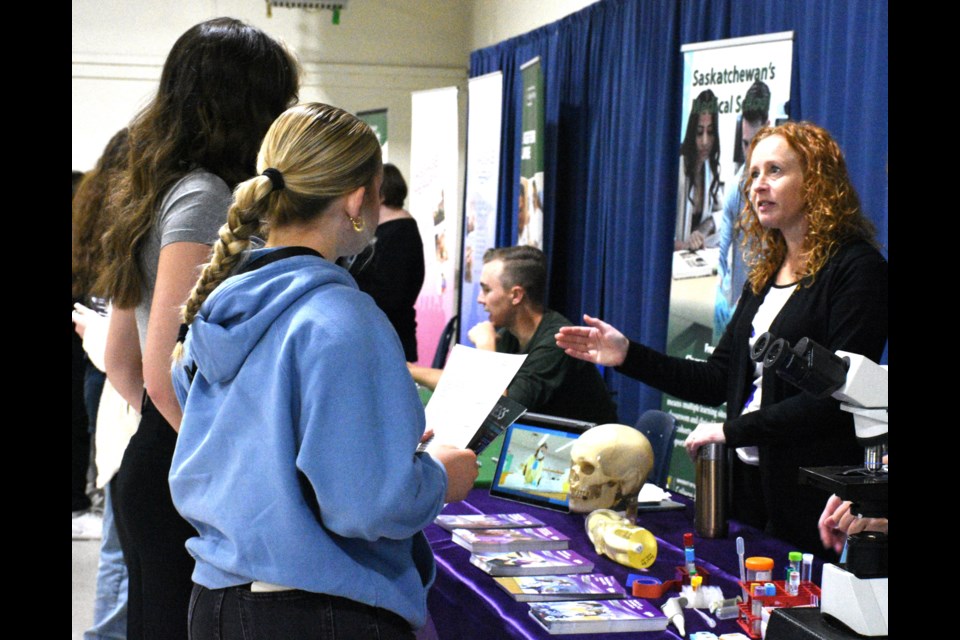 Robyn Mauza, program head for Saskatchewan Polytechnic's medical laboratory assistant and phlebotomy programs (right), speaks to students during the career fair. Photo by Jason G. Antonio