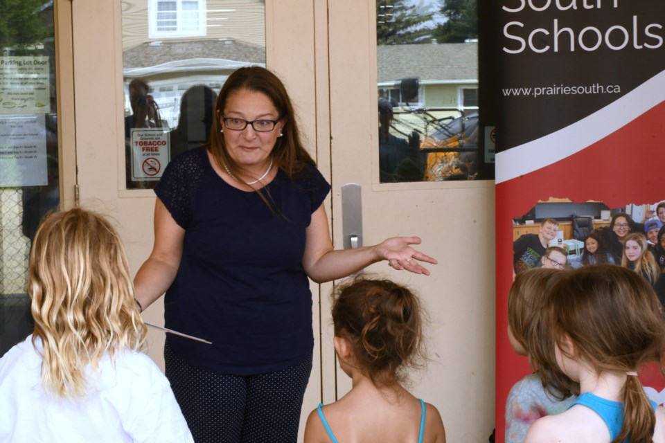 Students gather for pre-trip safety briefing before embarking on their first-ever ride on a school bus on the afternoon of Aug.15 at Lindale Elementary School.