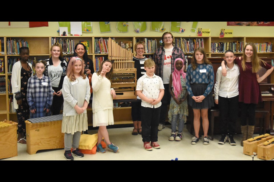 Students gather with teachers for a photo with the OrgelkidsCAN pipe organ.