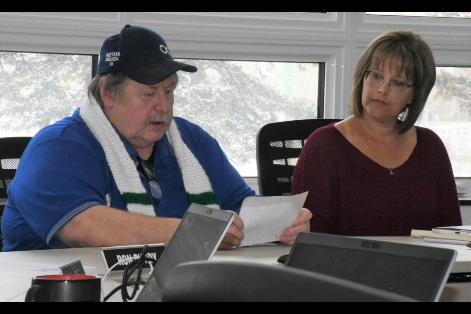 Darrell Hawman, president of New Southern Plains Metis Local 160 (left), says a prayer before the Metis flag is raised at the PSSD board office, while board chair Giselle Wilson looks on. Photo by Jason G. Antonio