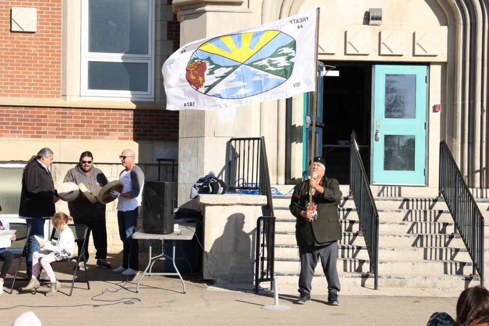 Veteran Deon Hassler raising Treaty 4 flag and the Red Dog Singers are performing the Flag and Victory song at Prince Arthur Community School. Photo by Saddman Zaman