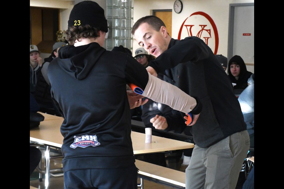 Principal Kelvin Anderson (right) demonstrates how to splint an arm injury on student Emery Schoenroth. Photo by Jason G. Antonio