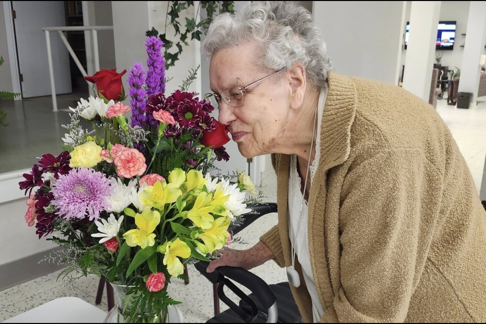 A resident inspects a completed floral arrangement prepared by Evans Florist owner Tina Cousens during a recent visit.