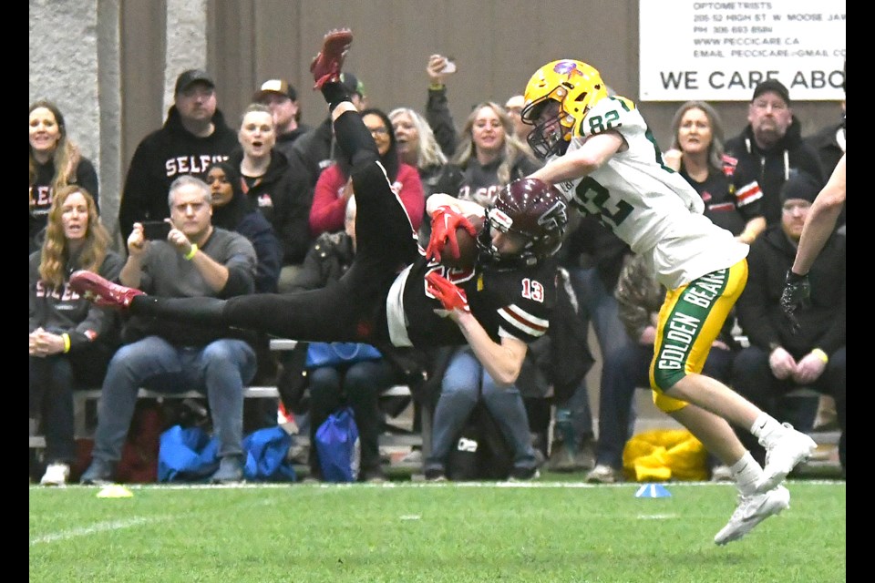 Sask Selects Varsity Black defender Wolfgang Berg hauls in an interception in front of Alberta Varsity Golden Bears receiver Lu Campbell.