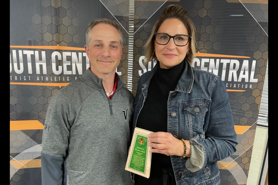 Longtime Vanier Collegiate coach Leanne Meili accepts the Saskatchewan High Schools Athletic Association provincial service award from Vanier athletic director Levi Broda.