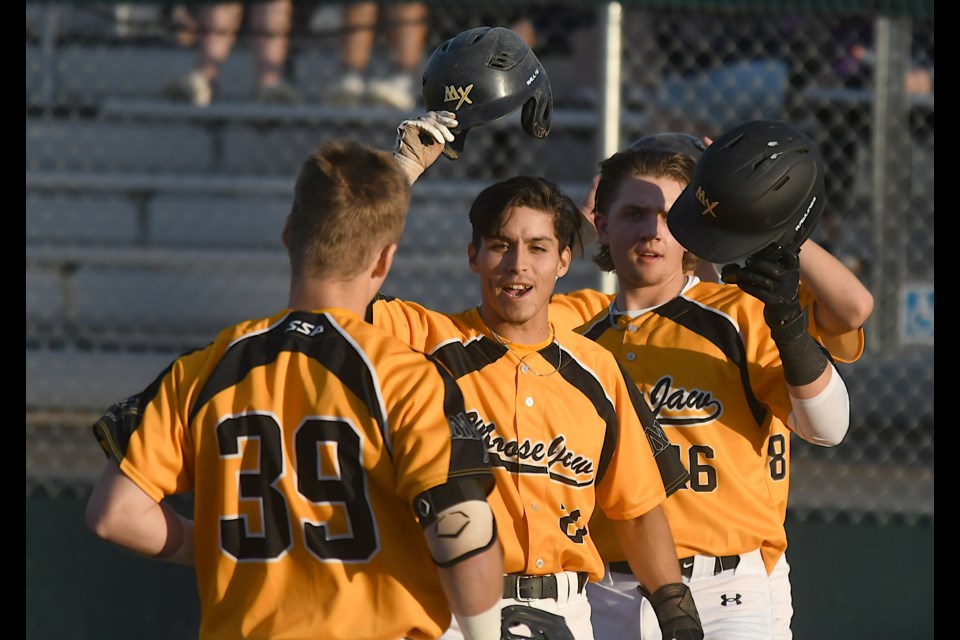 Miller Express baserunners Thomas Soto (centre) and Evan Deringer celebrate with Austin Gurney after his second-inning grand slam.