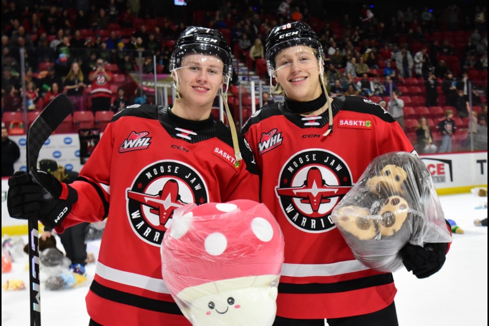 Teddy Bear Toss goal scorer Riley Thorpe (right) and set-up man Landen McFadden pause for a photo while clearing the ice.