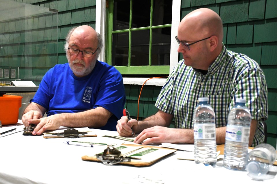 MJARC members John (VE5KS) (left) and Jason (VE5REV) prepare to send a Morse code message at the WDM on Feb. 22.