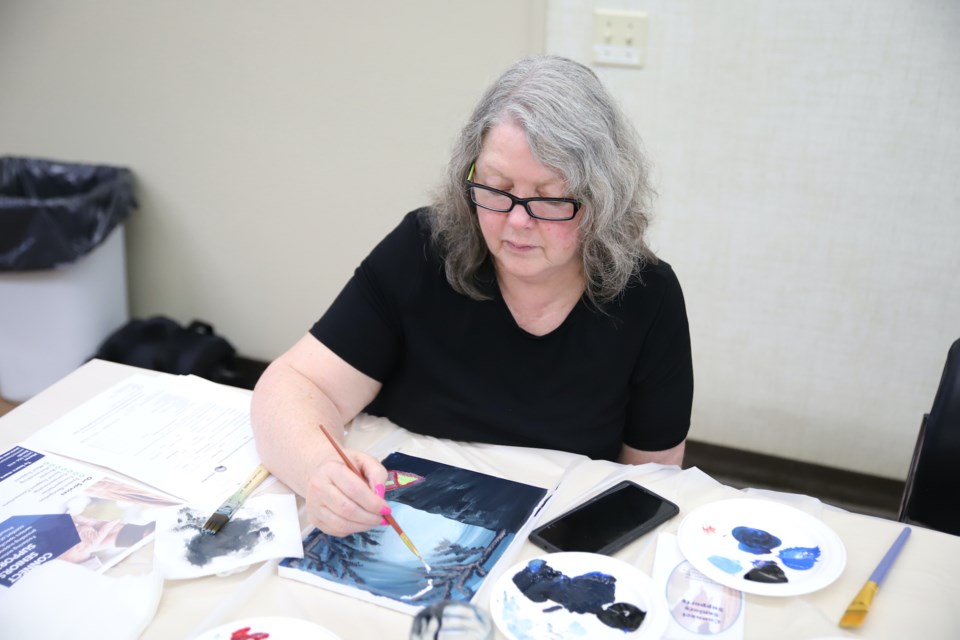 Anne Daley begins painting in a moon for her piece on Aug. 22 during an inaugural painting class, part of a new program called Connect Seniors Supports, offered by Accredited Supports to the Community in Olds.
Doug Collie/MVP Staff