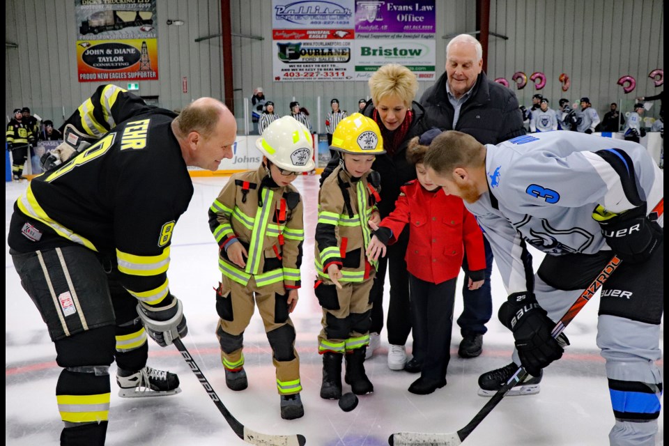 Innisfail mayor Jean Barclay and town councillor Gavin Bates, back row, take in the ceremonial puck drop before the start of the 3rd annual Battle of the Badges charity hockey game on Jan. 3 at the Innisfail Twin Arena. 
Johnnie Bachusky/MVP Staff