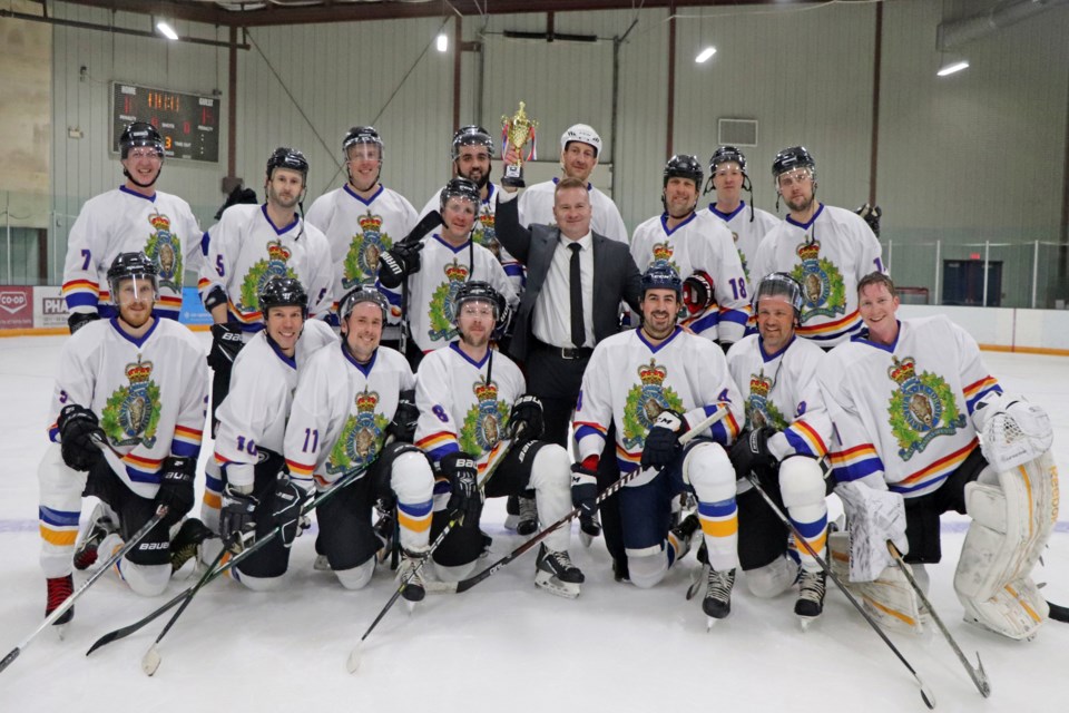 Innisfail RCMP Sgt. Ian Ihme, interim commanding officer of the Innisfail RCMP and coach of the detachment's hockey team, raises high the Battle of the Badges trophy with his team following the Mounties 15 - 10 victory over Innisfail Fire Rescue to claim the inaugural Battle of the Badges Charity Hockey game at the Innisfail Twin Arena on Jan. 6. Johnnie Bachusky/MVP Staff