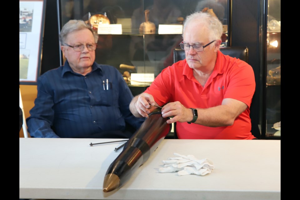 Olds Historical Society vice-president Bill Hall uses a tool to help pry the lid of the time capsule loose while treasurer Ernie Johnson who invented that tool, looks on.
Doug Collie/MVP Staff