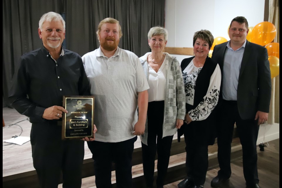 Sim’s Furniture & Bedding owner Lyle Blatz holds the award for Business of the Year along with employees, from left: James Clark, Joanne Prefontaine, and Joan Molitor. At the far right is Justin Menard, representing the award sponsor, Cam Clark Ford. 
Doug Collie/MVP Staff  