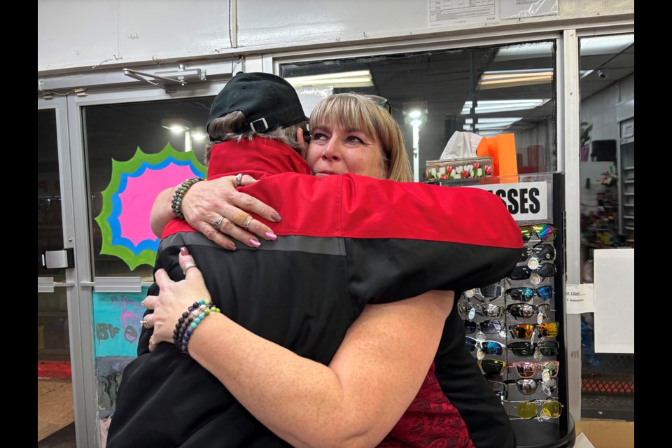 Patty Houchin, owner of Bowden's Reddi Mart, gives an emotional hug to her store's last customer John Williams on Jan. 31; the final day of operation for the Main Street business after serving the community for more than a half century. Johnnie Bachusky/MVP Staff
 