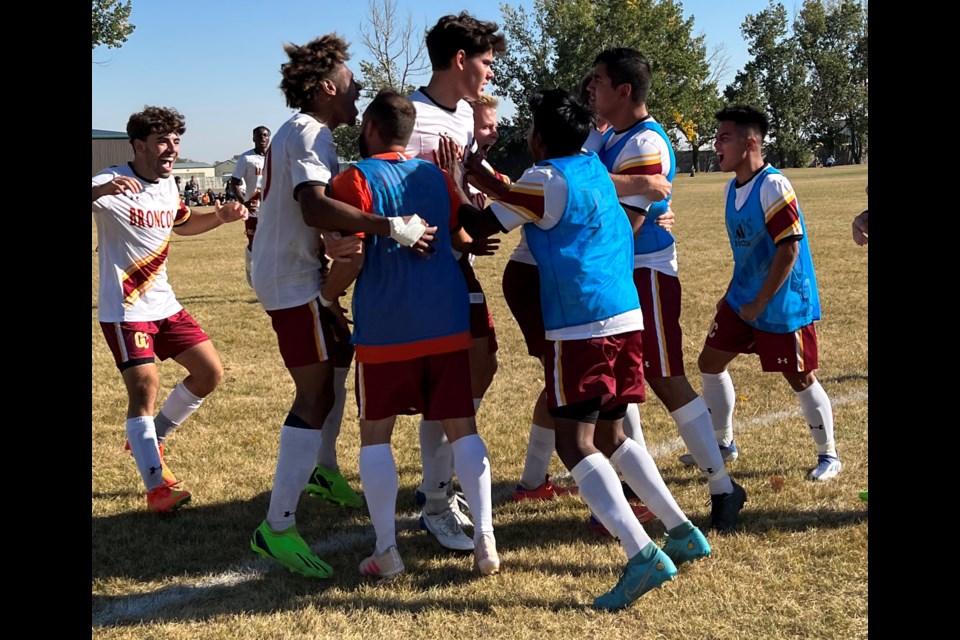 Valentin Kirchner, a leading scorer for the Olds College Broncos men's soccer team, is mobbed by teammates.