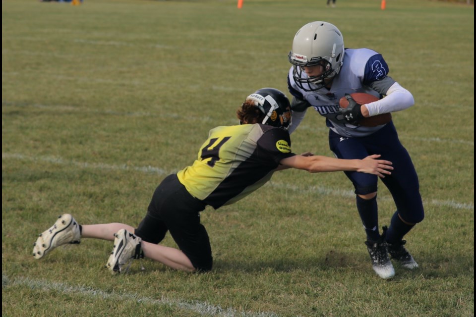 Bantam Bulldogs player Corben Christensen fends off an attempted tackle by  Drumheller player Holden Swanson.
Doug Collie/MVP Staff