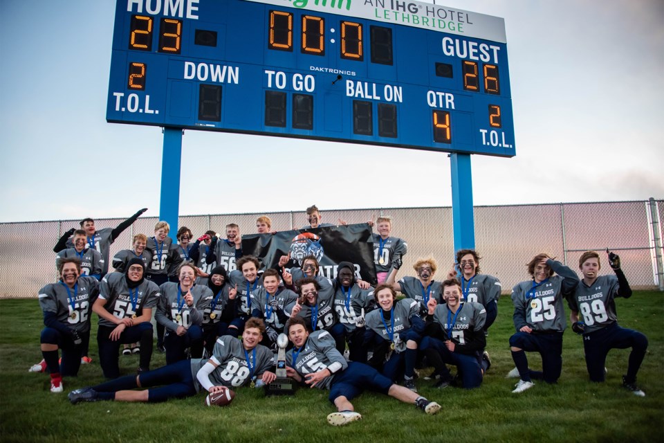 The Olds bantam Bulldogs celebrate after winning their second straight provincial championship Saturday, Nov. 11. They downed the  Claresholm Cobras 26-23.
Submitted photo