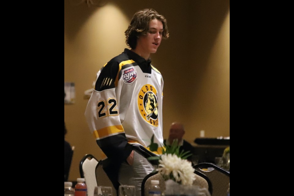 Team captain Cade Moxham, now up for the AJHL's Most Dedicated player, models his jersey for the crowd during the jersey auction portion of the Olds Grizzlys' recent awards banquet.