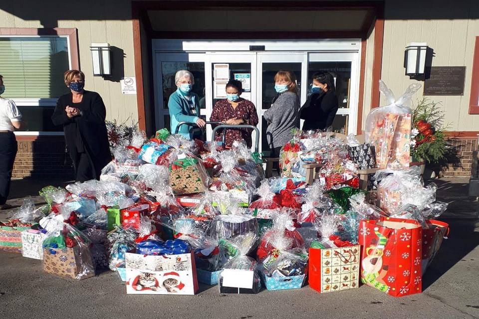 At left, Cheryl DeMaere-Ellis, southern manager and treasurer for Communities of Alberta Networking for Seniors Association (CAN), helps with the unloading of gifts to seniors at Bethany Cochrane in 2019. For the past two years her agency has been supporting the delivery of Christmas gifts to Innisfail seniors. Submitted photo