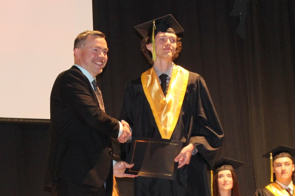 Cremona School principal Darryl Korody congratulates student Finn Matthewman during Friday's cap and gown ceremony