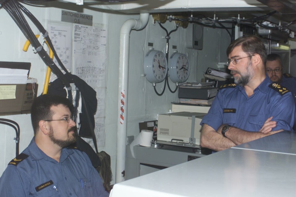 While at the the controls for electrical systems, James Cummings chats with the commander of the Royal Canadian Navy.