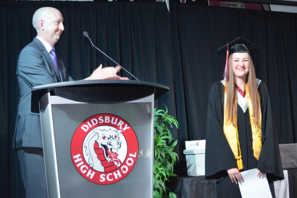 Band director Kirk Wassmer congratulates valedictorian Tyshia Bessey during Friday’s Didsbury High School cap and gown ceremony.
Dan Singleton/MVP Staff