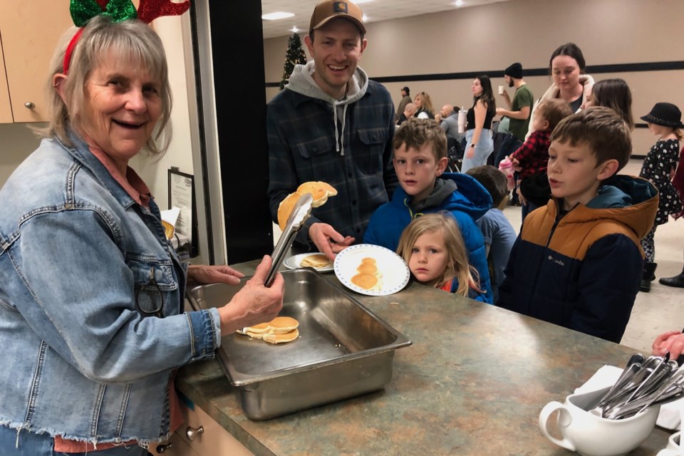 Didsbury mayor Rhonda Hunter serves up free pancakes during Saturday's Jingle & Mingle family event.