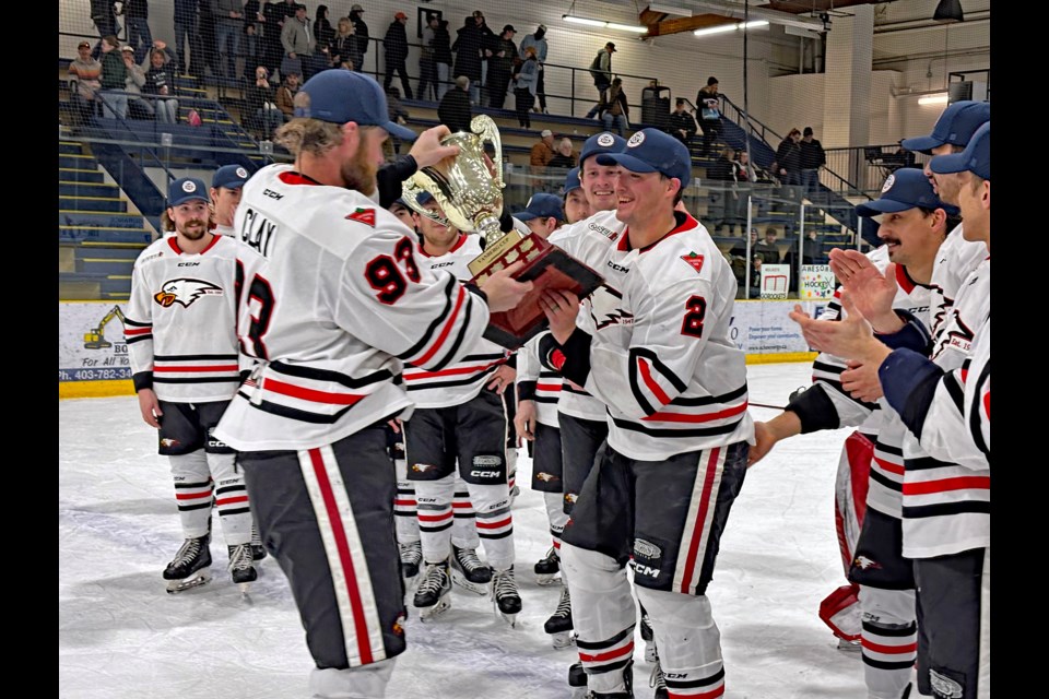 Innisfail Eagles forward Ty Clay, left, passes the Vanberg Cup to teammate Nick Bell as his team celebrates their senior men's AA North Central Hockey League championship following their 7-2 victory on March 22 against the Lacombe Generals. The Birds won the best of seven Vanberg Cup final series four games to one. Johnnie Bachusky/MVP Staff